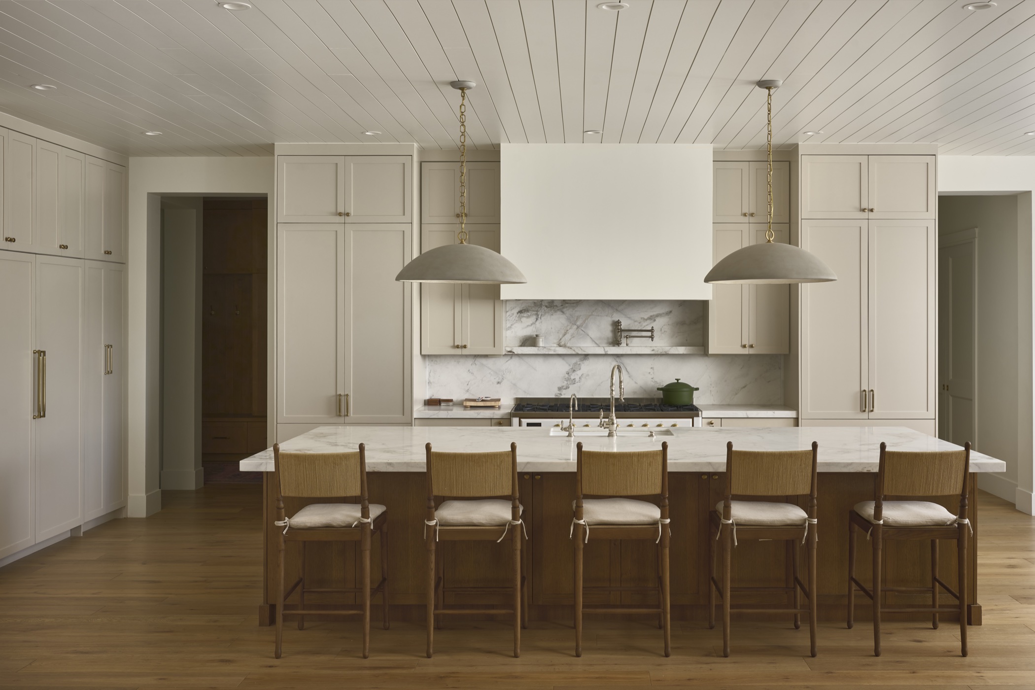 Warm oak kitchen and sculptural stone range wall at 53rd Place