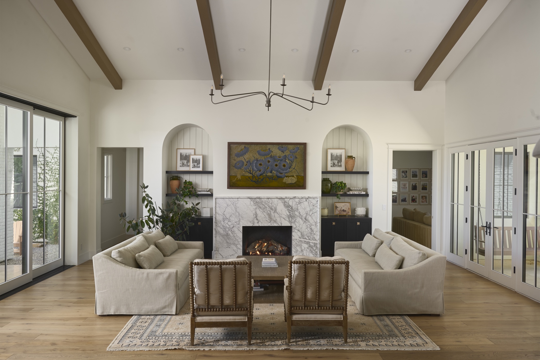 Living room with a stone fireplace and garden-facing doors