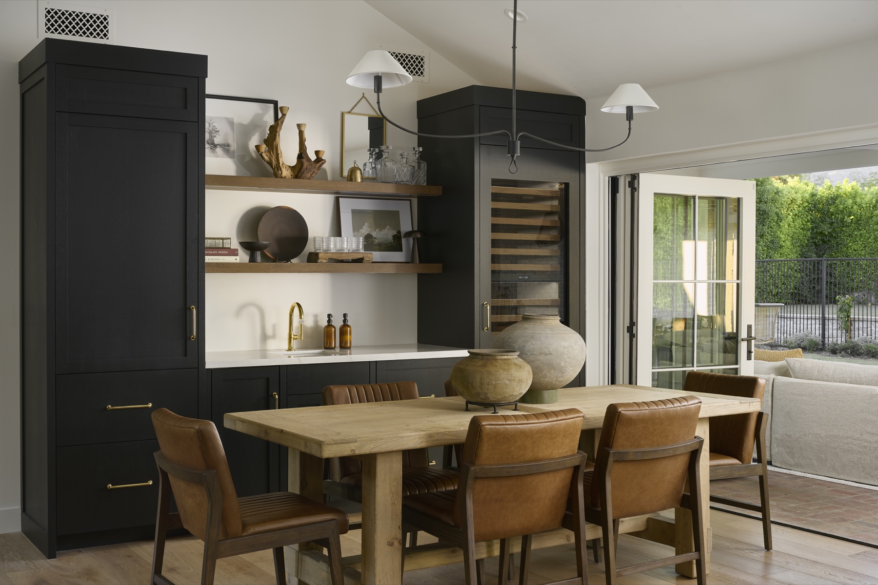 Dining table and dark beverage-storage cabinetry at Paisano Circle